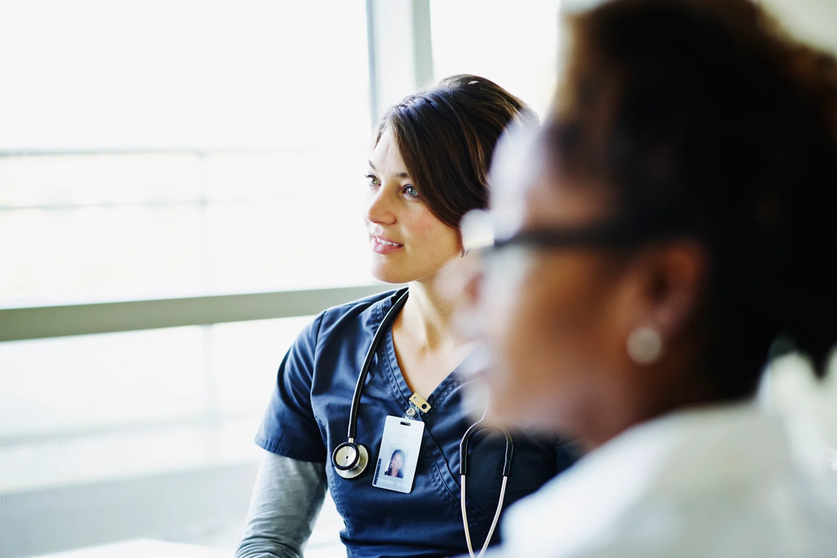 Female nurse listening during medical team meeting