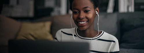 An image of a woman smiling while wearing an earphone